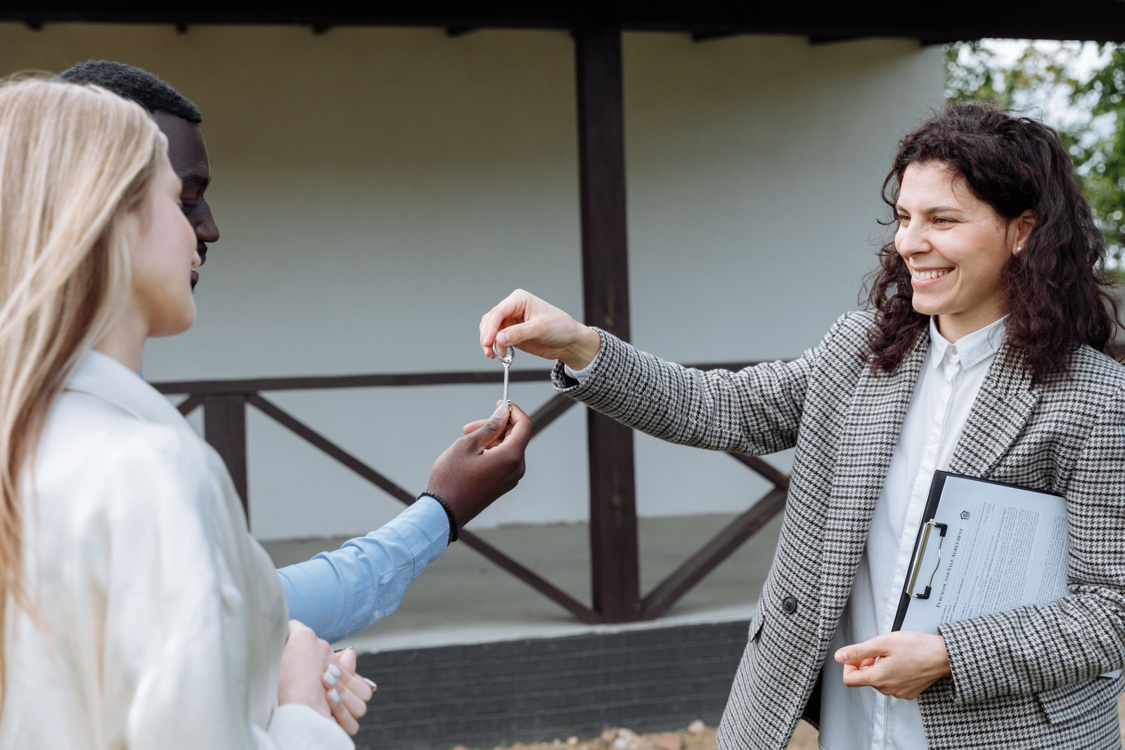 A real estate agent reviewing paperwork outside a listed home